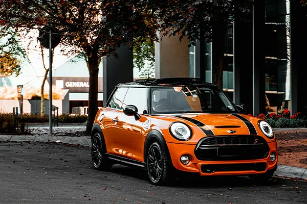 Orange mini cooper parked on side of road